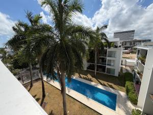 a palm tree in front of a building with a swimming pool at Dominik luxury penthouse in Cancún