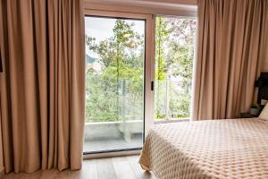 a bedroom with a bed and a large window at Cañada Suites by FMA Coliving in Salta
