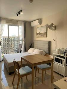a bedroom with a bed and a table with chairs at Condo at 16th Floor Free Pool Access with Private Balcony in Suba