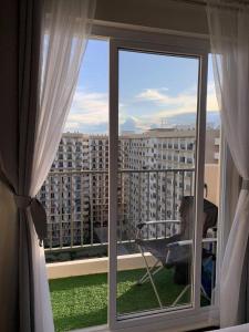 a room with a window with a view of a building at Condo at 16th Floor Free Pool Access with Private Balcony in Suba