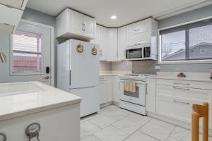 a kitchen with white cabinets and a white refrigerator at Downtown Casper Gem! Super Walkable Apartment in Casper