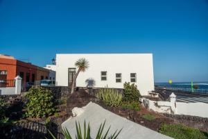 a white house with a palm tree in front of it at La Casa del Mar in Garachico