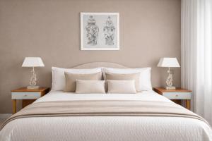 a bedroom with a large white bed with two lamps at Appartamento Corso Italia 269 in Sorrento
