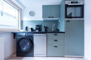 a kitchen with a washing machine and a washer at modernes Apartment bei Schlosspark Nymphenburg, Top Verkehrsanbindungen, free parking, perfekt für Business- City-Trips und Events in Munich