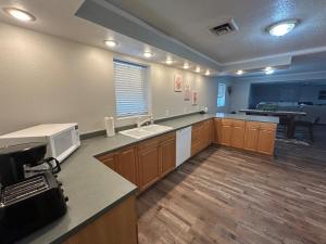 a large kitchen with a sink and a microwave at The Palace in Mandan
