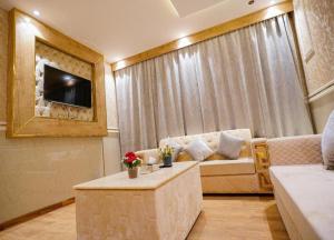 a living room with a couch and a tv at Lambert ApartHotel in Jeddah +57 photos