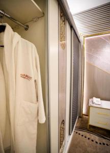 a white robe is hanging in a bathroom at Lambert ApartHotel in Jeddah