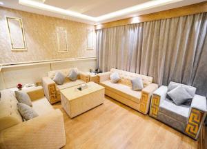 a living room with two couches and a table at Lambert ApartHotel in Jeddah