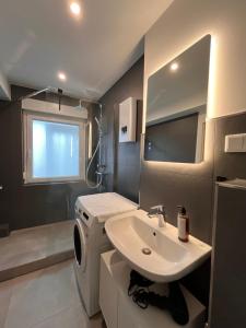 a bathroom with a sink and a washing machine at Neues 3-Zimmer-City-Apartment in Bielefeld mit Espresso, Arbeitsplatz und Parkplatz in Bielefeld
