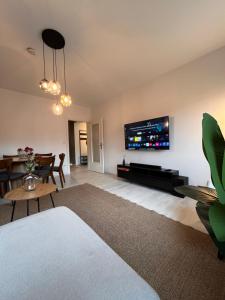 a living room with a flat screen tv on the wall at Neues 3-Zimmer-City-Apartment in Bielefeld mit Espresso, Arbeitsplatz und Parkplatz in Bielefeld