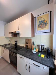 a kitchen with white cabinets and a black counter top at Neues 3-Zimmer-City-Apartment in Bielefeld mit Espresso, Arbeitsplatz und Parkplatz in Bielefeld +11 photos