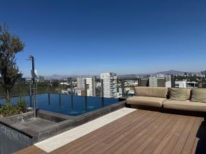 a living room with a couch sitting on a roof at Luxury apartment near Andares in Guadalajara