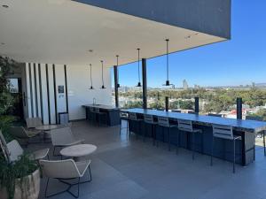 a bar with chairs and a blue counter with a view at Luxury apartment near Andares in Guadalajara
