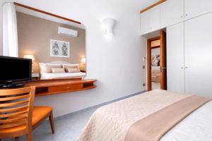 a bedroom with a bed and a desk with a television at Appartamento Corso Italia 269 in Sorrento