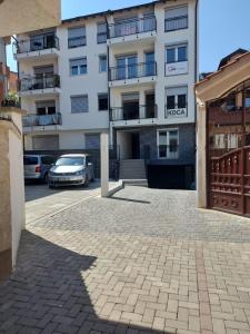 a building with a car parked in a parking lot at River Side Apartment in Prizren