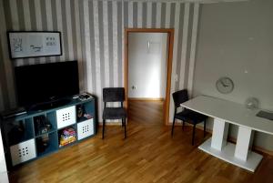 a living room with a tv and a table and chairs at Südharzperle in Bad Lauterberg