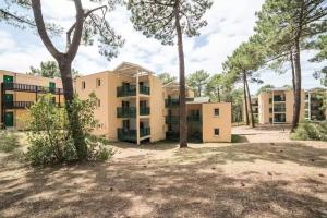 an apartment building with trees in front of it at Appartement Carcans Maubuisson in Carcans