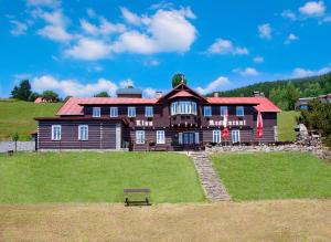 a large house with a bench in front of it at Chata Lion in Pec pod Sněžkou