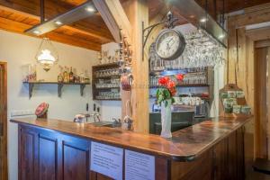 a bar in a restaurant with a clock on the wall at Chata Lion in Pec pod Sněžkou