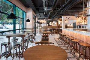 a bar with tables and stools in a restaurant at Four Points Flex by Sheraton Malaga Centre in Málaga