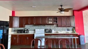 a kitchen with wooden cabinets and a ceiling fan at Quinta Sunset, Lago de Coatepeque in El Congo