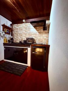 a small kitchen with a stove and a sink at Chalé Sertão da Boa Vista in Rio Claro +10 photos