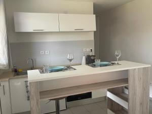 a kitchen with a counter with two plates and wine glasses at Sweet Escape in Montjoly
