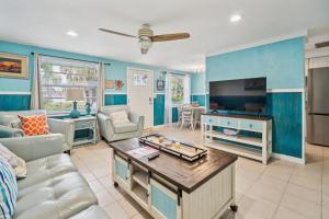 a living room with a couch and a tv at pink peacock in Holmes Beach