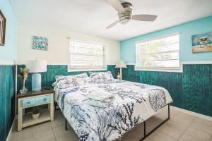 a bedroom with a bed and a ceiling fan at pink peacock in Holmes Beach