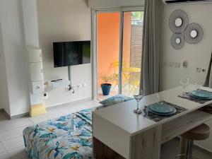 a living room with a table and a couch at Sweet Escape in Montjoly