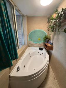a white tub in a bathroom with a window at בשקט שלך in Mattat +54 photos