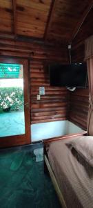 a room with a bed and a tv and a window at Mi CASA in Sierra de los Padres
