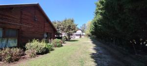 a dirt road next to a wooden barn at Mi CASA in Sierra de los Padres