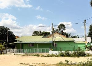 a green house with a green roof at Simple house in Lyndiane Zig in Ziguinchor