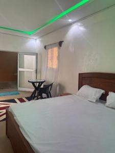 a bedroom with a large bed with a green light at Simple house in Lyndiane Zig in Ziguinchor