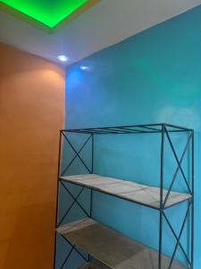 a shelf in a room with a blue wall at Simple house in Lyndiane Zig in Ziguinchor +6 photos