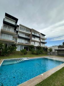 an apartment building with a swimming pool in front of it at Apartamento con acceso directo al río in Veracruz