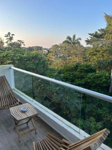 a balcony with two chairs and a view of trees at Apartamento con acceso directo al río in Veracruz