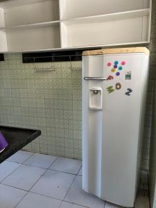 a white refrigerator in a kitchen with magnets on it at Casa com 2 quartos in Cabo Frio