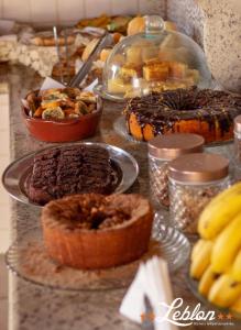 a table topped with different types of pastries and desserts at Hotel Leblon in Peruíbe
