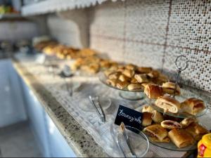 a buffet line with plates of pastries on display at Hotel Leblon in Peruíbe