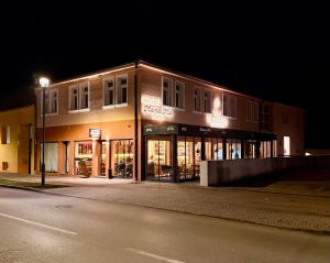 a building on the side of a street at night at Vila Vladorena in Požega