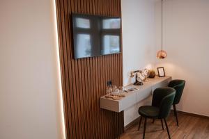 a room with a desk with two chairs and a window at Vila Vladorena in Požega