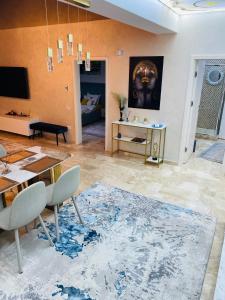 a living room with a dining table and a rug at Luxury Mamaia Central in Mamaia