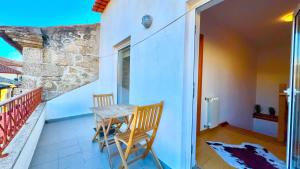 a small balcony with a table and two chairs at Casa Dos Passos in Guarda