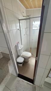 a small bathroom with a toilet and a shower at Hotel Hallas in Betim