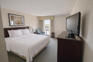 a hotel room with a bed and a flat screen tv at Hotel Lotus Kansas City Stadium in Kansas City