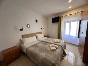 a bedroom with two beds and a window at P&R hostals Codolar in Tossa de Mar