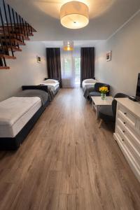 a room with three beds and a staircase at Ośrodek TVP Sarnówek in Szałkowo
