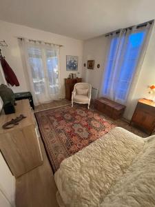 a bedroom with a bed and a chair in it at Villa Danemark in Colombes